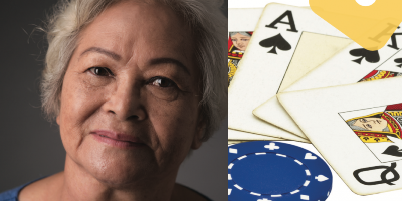 Older person smiling. Cards and a poker chip on table.